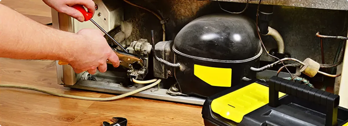 Refrigerator repair technician fixing the compressor and wiring in Plantation, FL