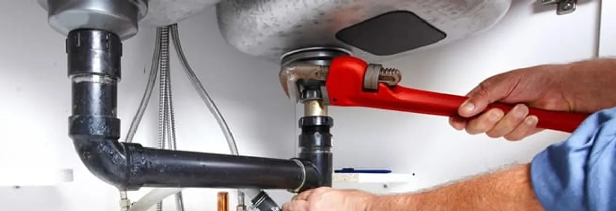 Garbage disposal repair technician tightening the sink drain and disposal connection in Pembroke Pines, FL